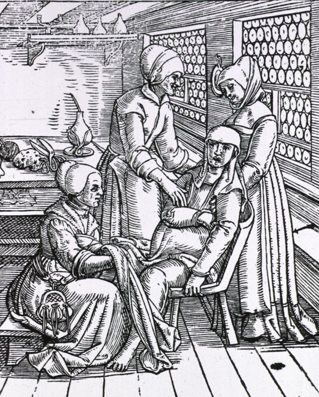 Three midwives attending to a pregnant woman