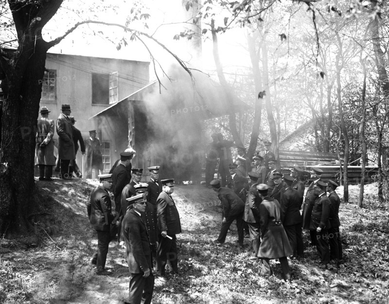 Men in uniform outside a house on fire