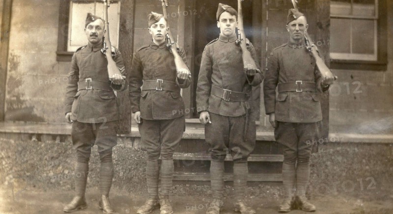 Four airmen holding rifles over their left shoulders