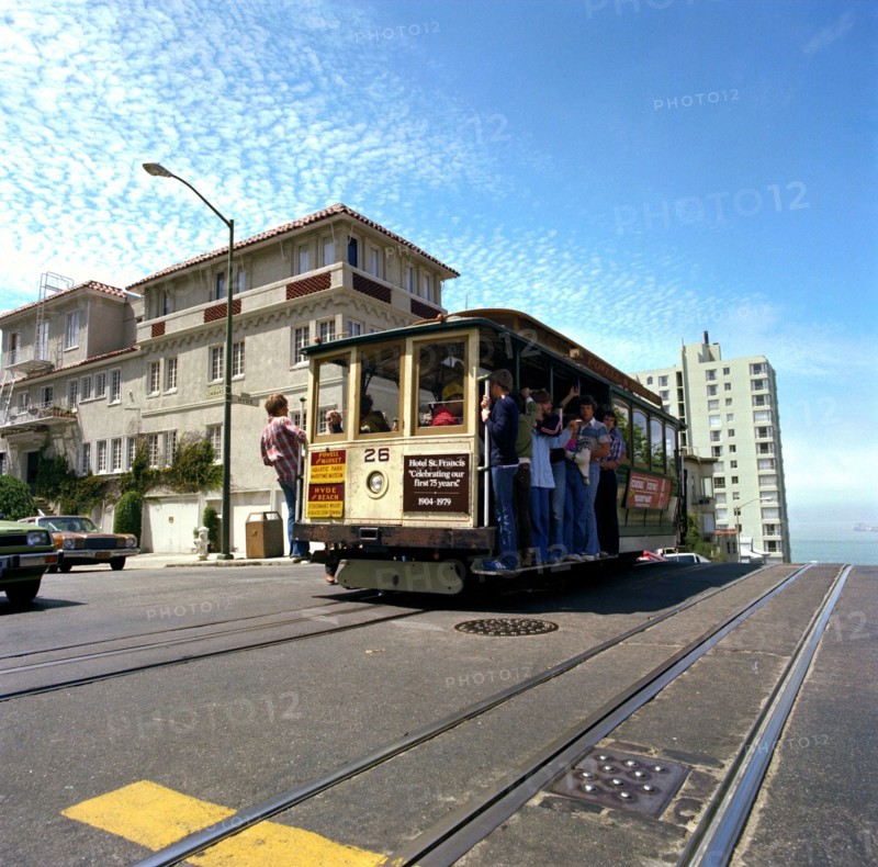 Tourists riding the famous San Francisco cable car