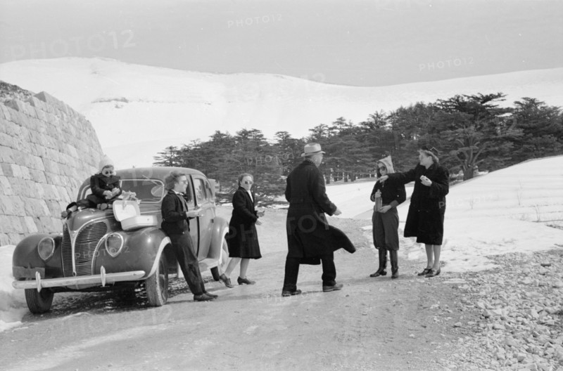 Photographic party stops for a cold snowy lunch ca. 1946