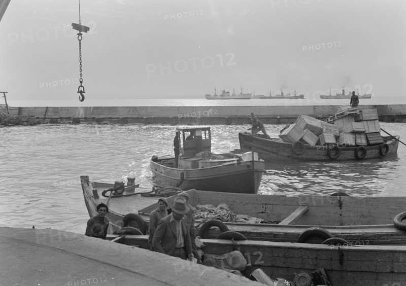 Boats in Tel Aviv Harbor. Setting sun, looking across lighter basin ca. 1939