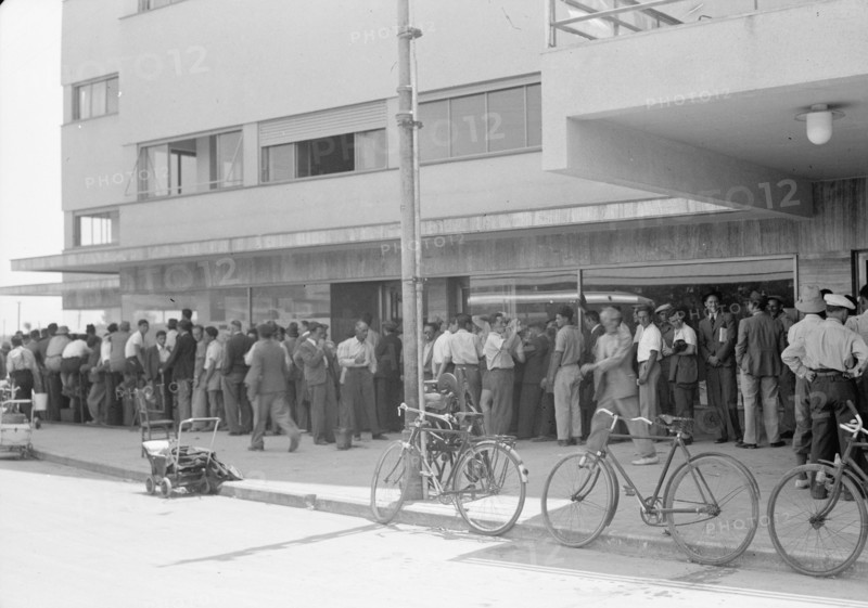 Jewish chauffeurs in a long line / queue in Tel Aviv acquiring licenses ca. 1939
