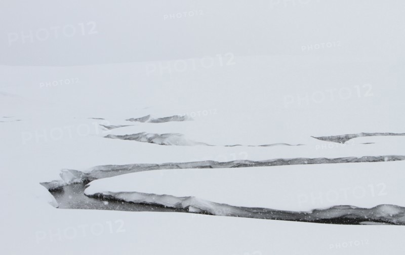 A creek winds through a snowy valley. Antler Creek in Hayden Valley in Yellowstone National Park; Date:  3 February 2015