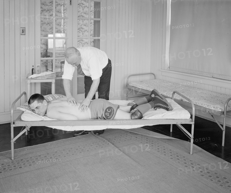 An athlete receiving a rub down by a trainer ca.  between 1910 and 1925