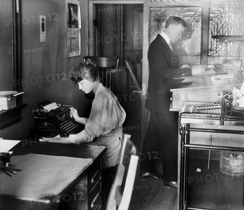 Man and woman working in an accountant's Office, woman typing ca.  between 1910 and 1920