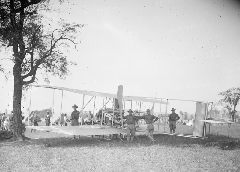 Soldiers standing next to a bi-plane ca.  between 1910 and 1920
