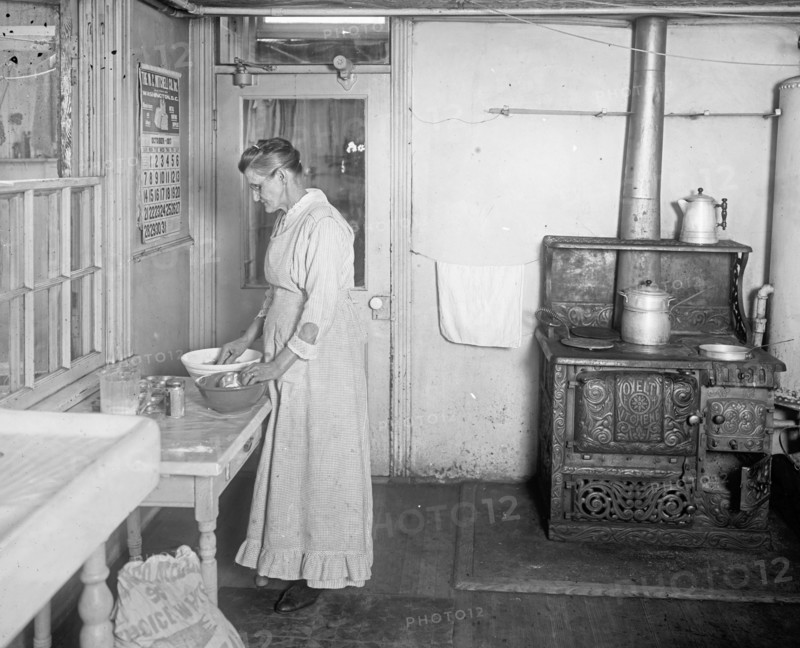 Early 20th century elderly woman working in a kitchen  ca.  between 1910 and 1935