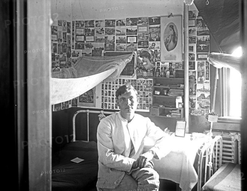 Young man in dormitory room ca.  between 1910 and 1920