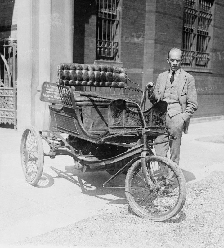 Carl W. Mitman, Curator of Engineering of the Smithsonian Institution photographed with a three-wheel automobile which has been recently acquired by that institution ca. 1924