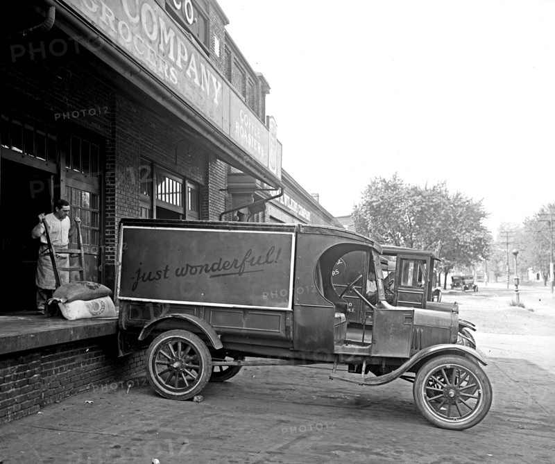 Man loading food onto a Ford Motor Company delivery truck ca.  between 1910 and 1926