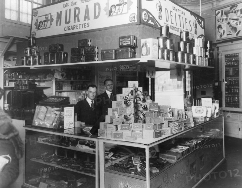 Interior of People's Drug Store, 7th and K Streets, Washington, D.C., with employees behind counter with display of smoking products including pipes, cigars, tobacco, and cigarettes ca. between 1909 and 1932