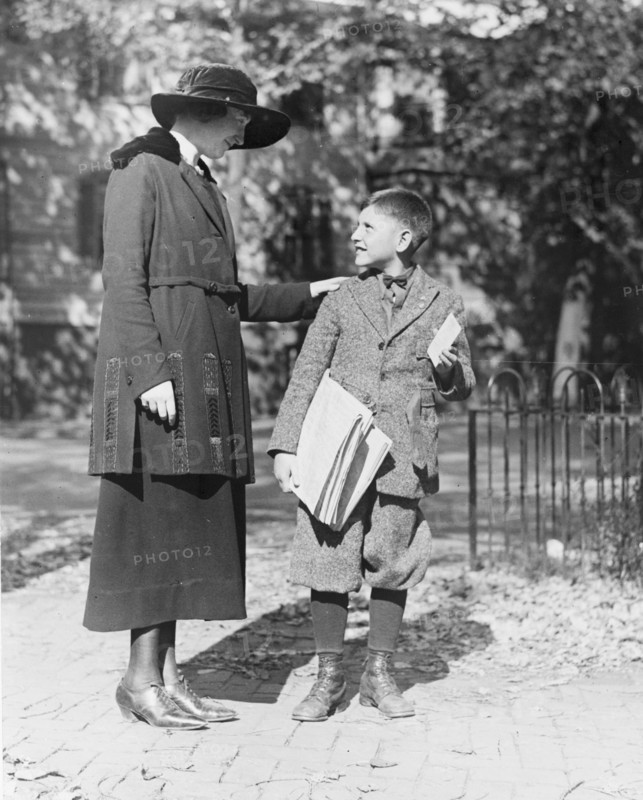 A policewoman in training, speaking to a young man, possibly a newsboy ca. 1909