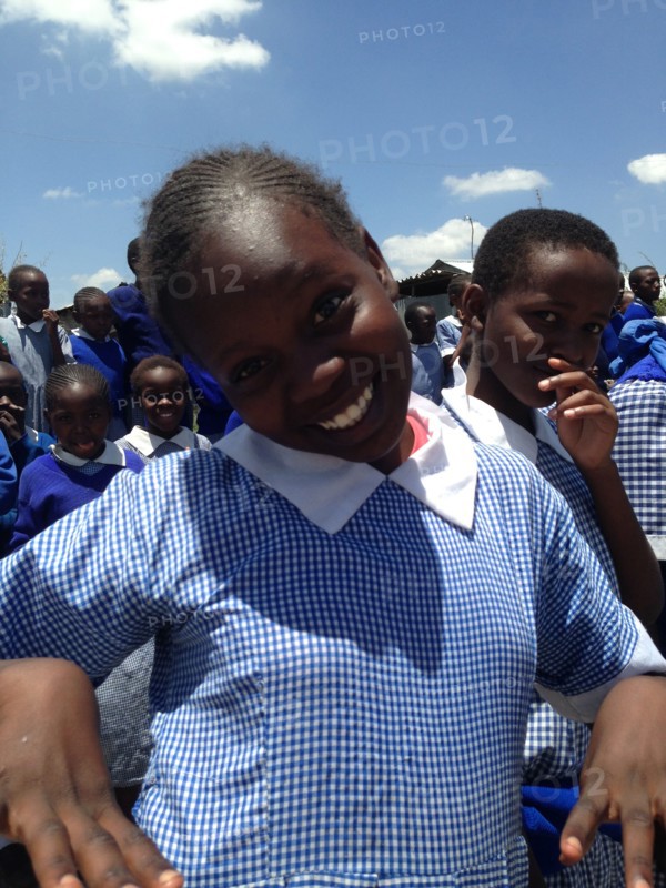 A student smiles at the camera at a groundbreaking in Kibera Kenya (urban slum area) ca. 27 February 2014