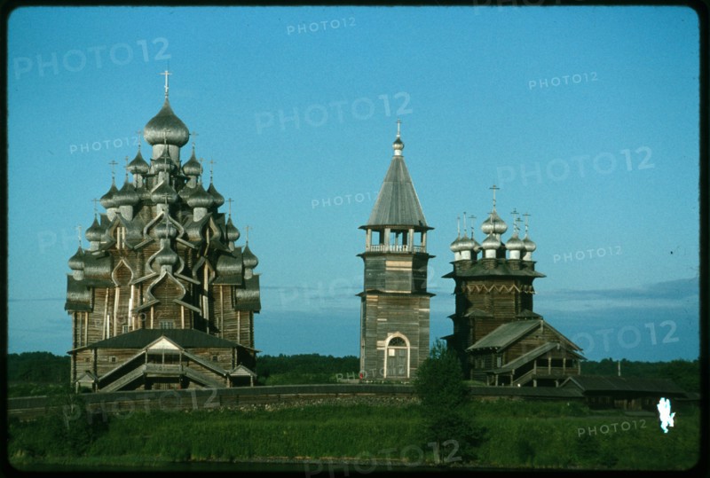 Pogost ensemble, Church of the Transfiguration (1714) (left); bell tower (19th century); Church of the Intercession (1764), west view, evening, Kizhi Island, Russia; 1993
