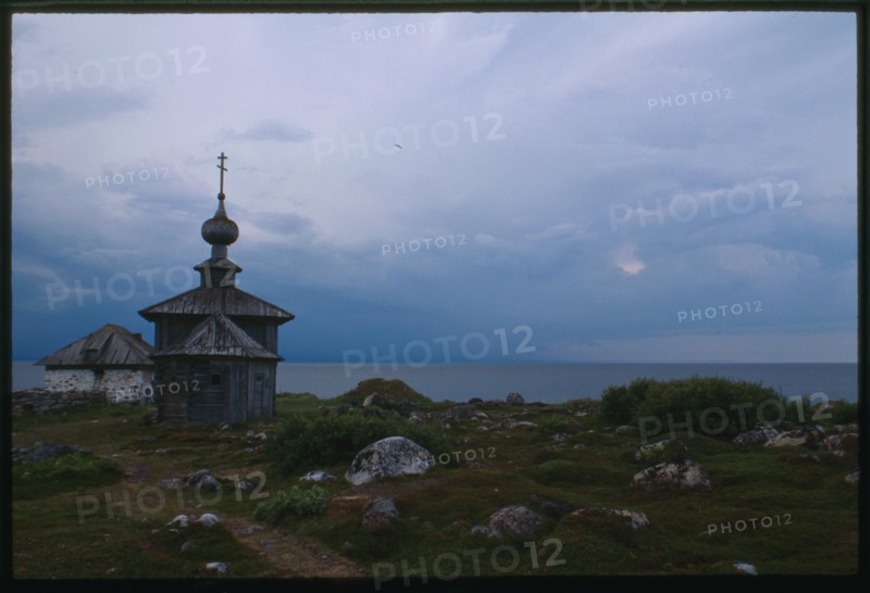 Church of St. Andrew (1702), east view, with stone dwelling (mid 16th century), and White Sea in background, Bol'shoi Zaiatskii Island, Russia; 1999