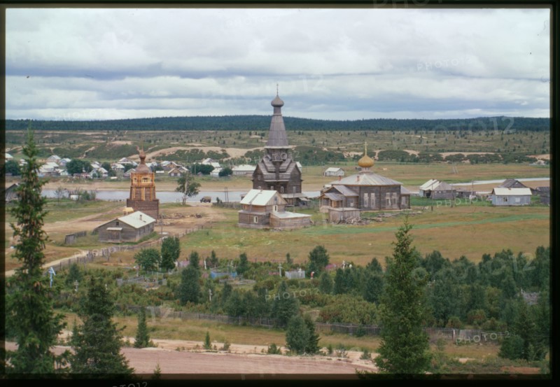 Northeast panorama with Church of the Dormition (1674) (center), and Church of St. Afanasii (1857) (right), with Varzuga River in background, Varzuga, Russia; 2001
