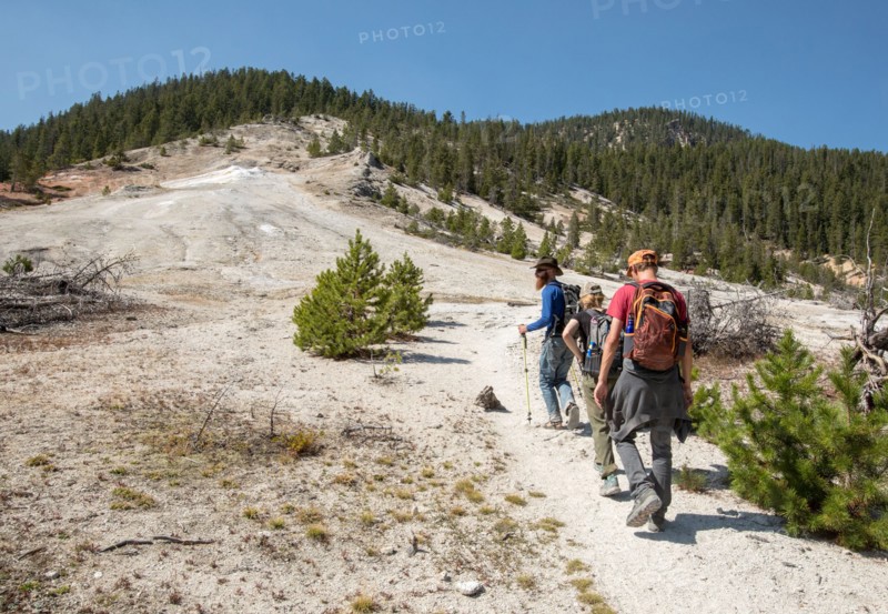 Hikers on a trail going uphill with hydrothermally altered rock all around. Seven Mile Hole Trail in Yellowstone National Park; Date: 11 September 2017