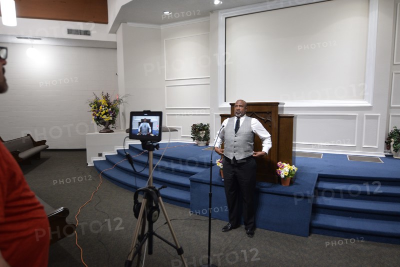 During the Covid-19 pandemic, some churches chose to record sermons to play on their websites and through streaming services to replace in person worship. Here, a technician records a minister as he preaches to the camera.