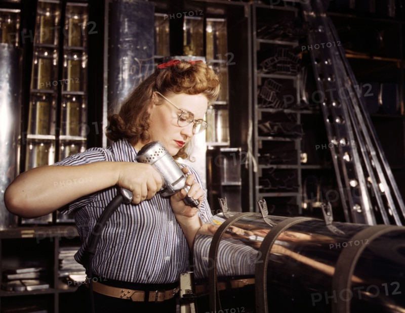 A woman operating a hand drill at North American Aviation