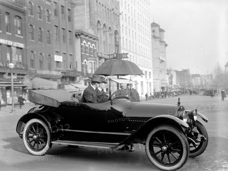 Early 1900s automobile observing the stop and go signs on a Washington D.C. Street