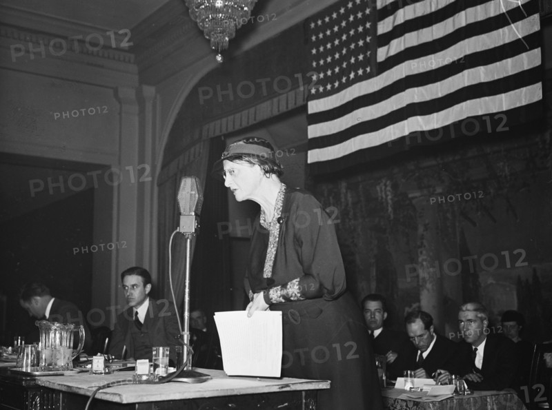 Woman speaking into a microphone at a patriotic event