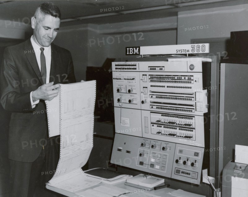 Worker reading printout sheet July 1967 in front of IBM 360