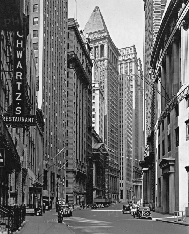 1930s New York City - Buildings lining Broad Street, including Schwartz's restaurant, left foreground, and a building with scaffolding (looking towards Wall Street (ca. 1936)