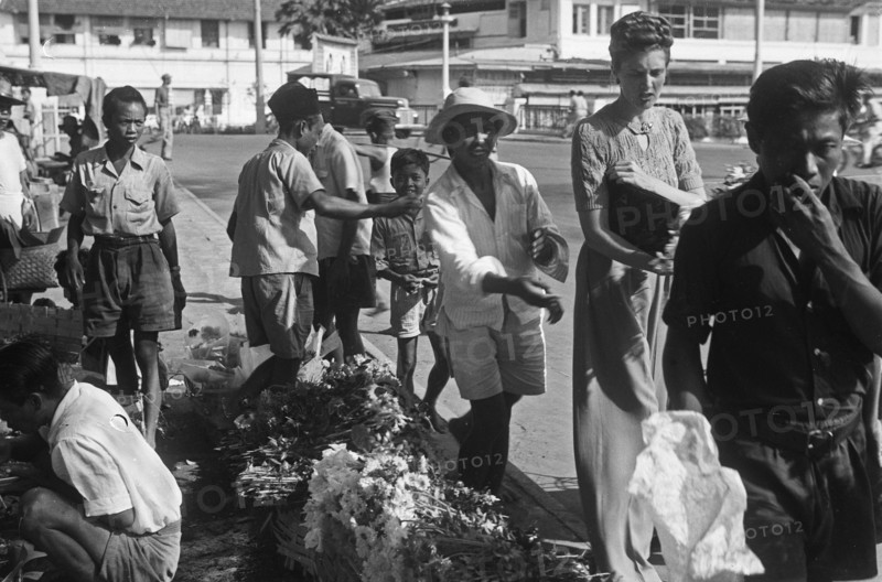 1940s Indonesia - Street scenes. A Dutch woman buys flowers from a florist - 24 August 1948