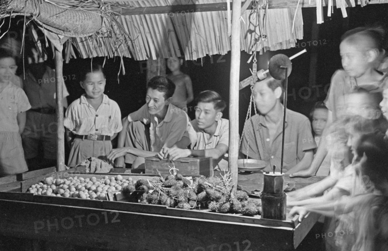 Man selling fruit at a stall in Banka, Indonesia, Dutch East Indies ca. 1947
