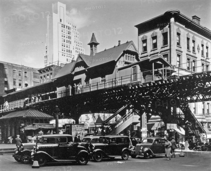 Elevated railroad station in Hanover Square in Lower Manhattan, cars below, buildings of various eras beyond ca. 1936