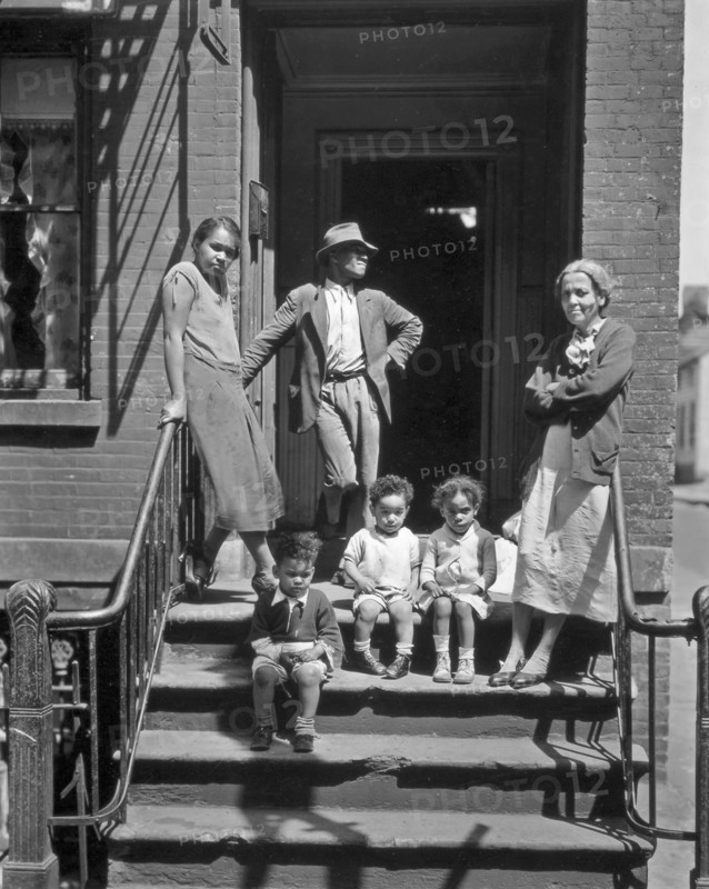 Three generations of African Americans on stoop of brick home with iron rails on steps. Jay Street, No. 115, Brooklyn ca. 1936