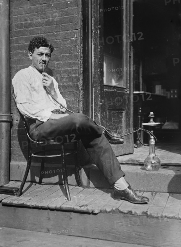 Syrian shopkeeper smoking a hookah pipe ca. 1910-1915
