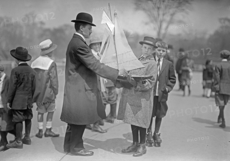 A man and boys with a model yacht at Conservatory Lake, Central Park, New York City ca. 1910-1915