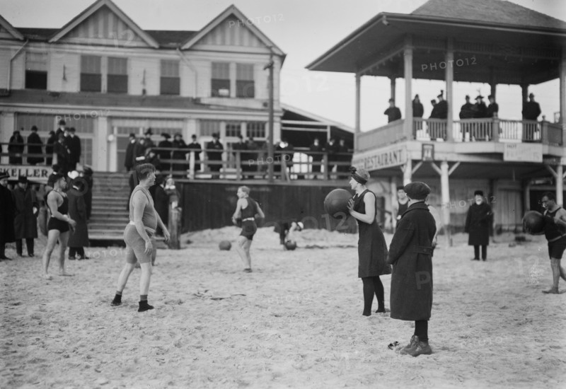 People on the beach at Coney Island throwing balls (possibly medicine balls) ca. January 1915