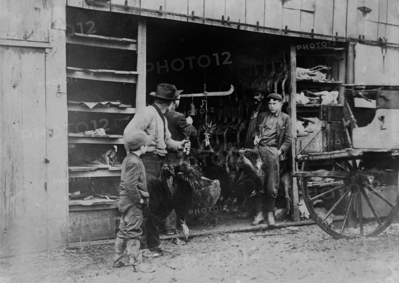 A father and a son buy their Thanksgiving turkey from a local vendor ca. 1910-1915