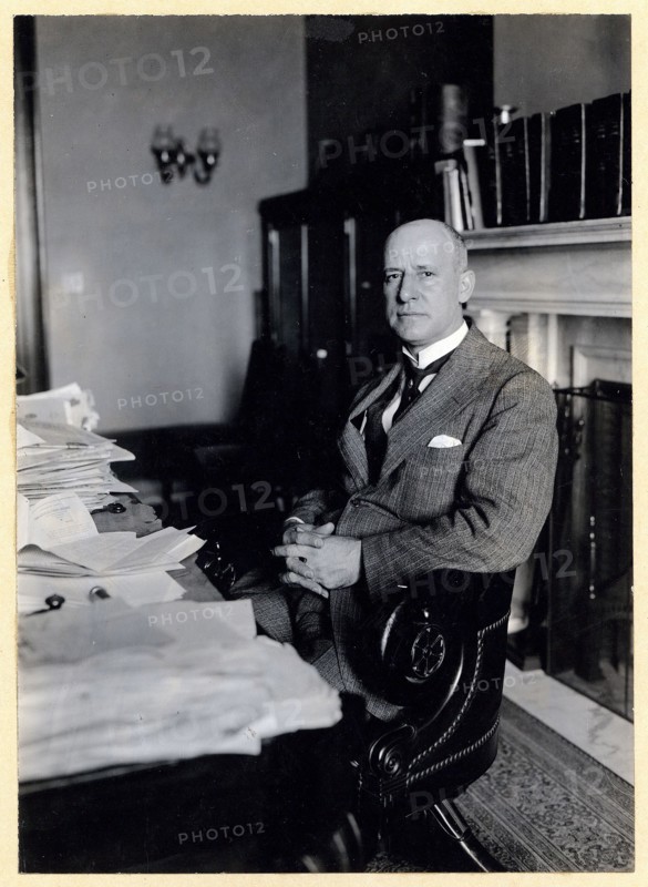 Miles Poindexter, three-quarter length portrait, seated at desk, facing left ca. 1920-1932