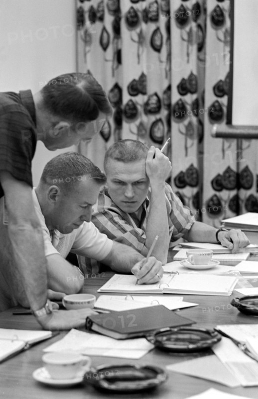 (2 Dec. 1965) Gemini-7 astronauts James Lovell Jr. (center) and Frank Borman (right) review mission requirements for their Gemini-7 flight.