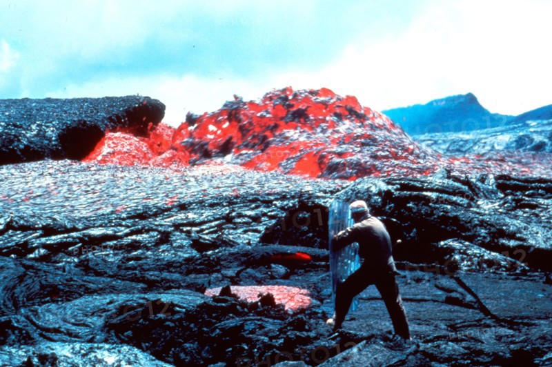 Taken on March 31, 1984, in Hawaii Volcanoes National Park, we see Ed Wolfe taking a temperature measurement on a sluggish channel eddy on Mt. Kilauea which had begun erupting in 1983.