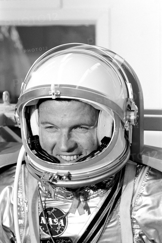 (1963) Astronaut L. Gordon Cooper Jr., prime pilot for the Mercury-Atlas 9 (MA-9) mission, relaxes while waiting for weight and balance tests to begin.