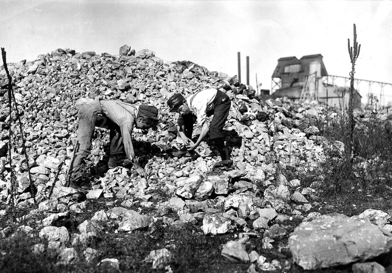 Two young boys collecting rocks, 1912