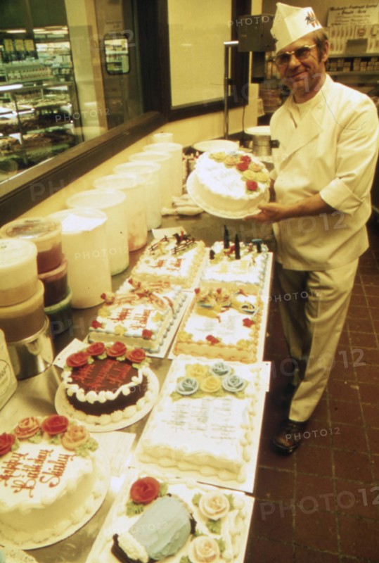 German Immigrant Hans Strzyso Is the Chief Baker at Madsens Supermarket. He Specializes in All Types of Decorated Cakes and Ethnic German Baked Goods Which Are Made Fresh Daily ca. 1975