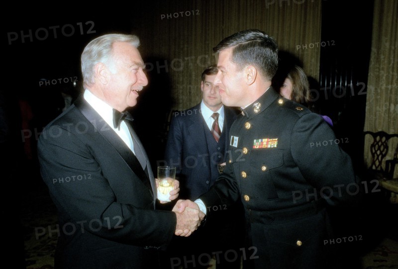A Marine Corps major shakes hands with Walter Cronkite