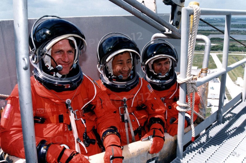 STS-84 Mission Specialists, from left, C. Michael Foale, Edward Tsang Lu and Elena V. Kondakova practice emergency egress procedures in a slidewire basket at Launch Pad 39A ca. 1997