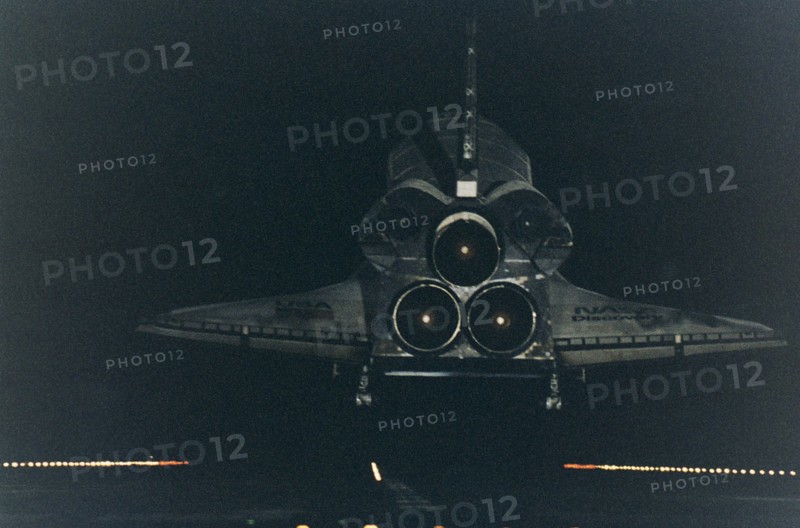 Under the cover of darkness, the Space Shuttle orbiter Discovery glides in for a landing on Runway 15 at KSC's Shuttle Landing Facility ca. 1997