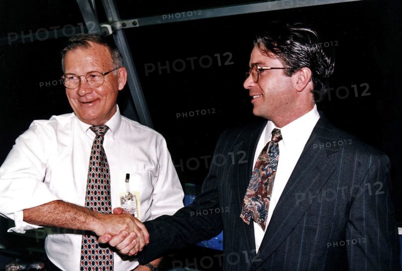 KSC Center Director Jay F. Honeycutt, at left, shakes hands with Scott Cilento, the new flow director of the Space Shuttle orbiter Discovery, in the firing room of the Launch Control Center (LCC) during the STS-82 launch of Discovery  ca. 1997