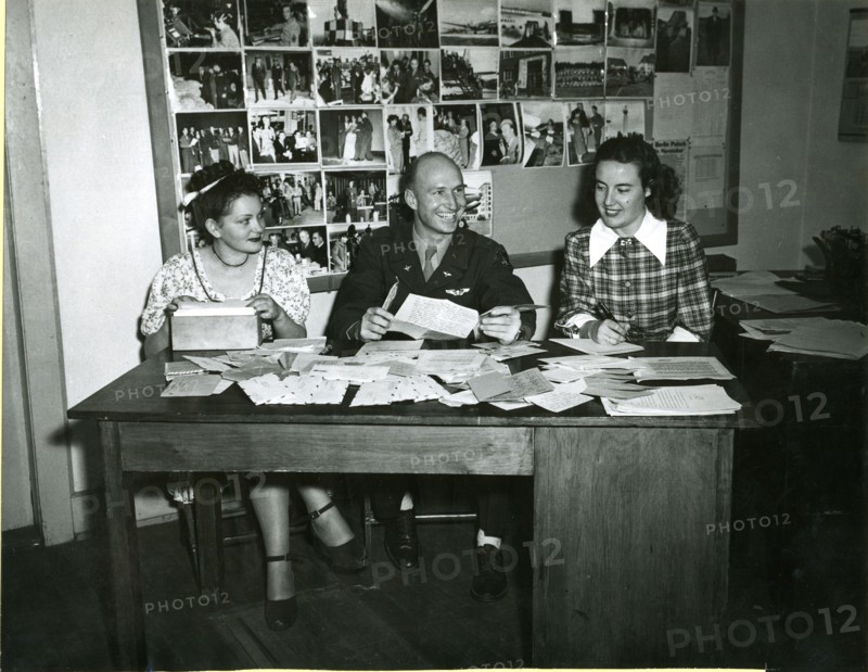Answering letters from grateful Berlin children who have received some of the 'candychutes' dropped by First Lt Gail S Halvorsen, Garland, Utah, originator of Project Little Vittles, is a sizeable job. Halvorsen is shown here with his two assistants, Miss Gisela Hering (left), translator, and Mrs Margaret Preston, secretary, at work at the Rhein