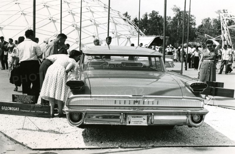 Interested spectators look inside an Oldsmobile, 1959
