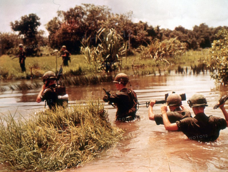 16th Armored Division members cross a jungle river in previous Viet Cong territory. Vietnam, 9/65.