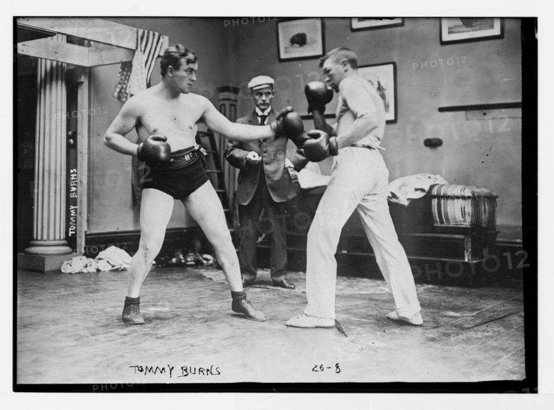 Boxer Tommy Burns (left) sparring with a partner. Circa 1908.